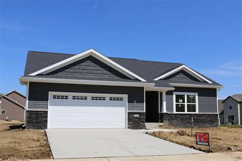 Light grey with white trim can achieve an entirely new look when just a slight hint of color modifies the sidings overall tone. . Dark gray siding ranch house